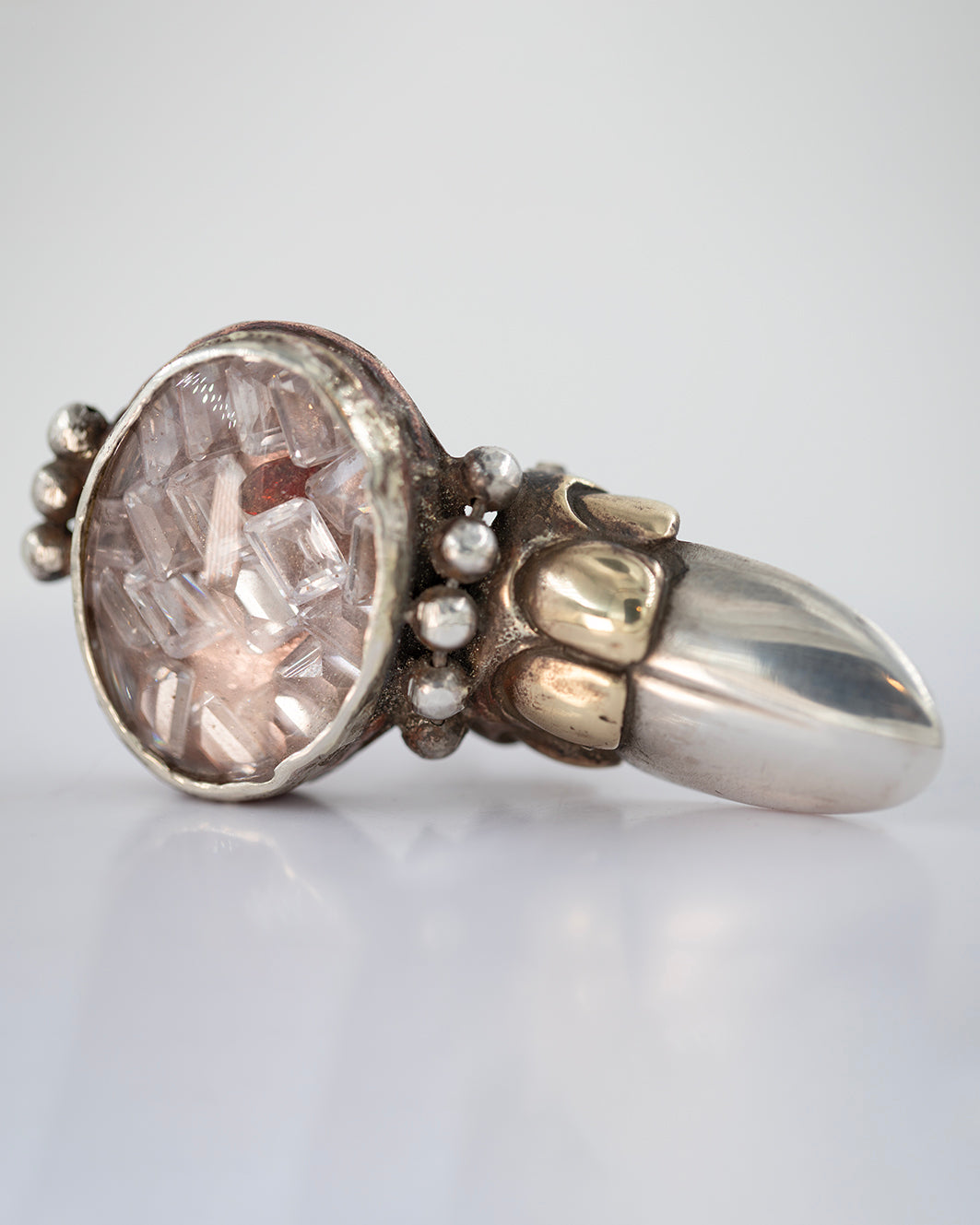 Big ring with zircons and garnet, glass. Copper, brass, silver./ Wielki pierscien z cyrkoniami i granatem. Szklo. Miedz, mosiadz, srebro.