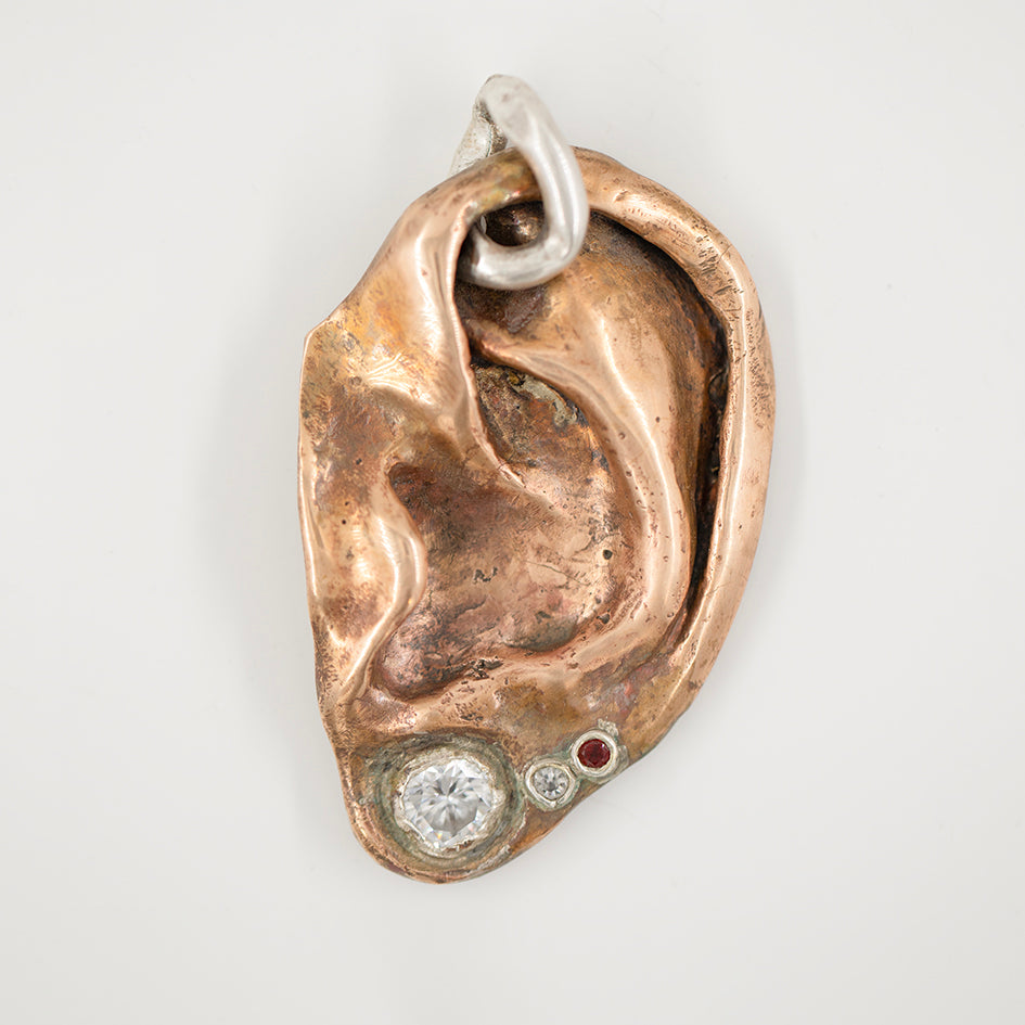 Ear pendant. Bronze, zircons, garnet. / Wisior w kształcie ucha. Braz, cyrkonia, granat.