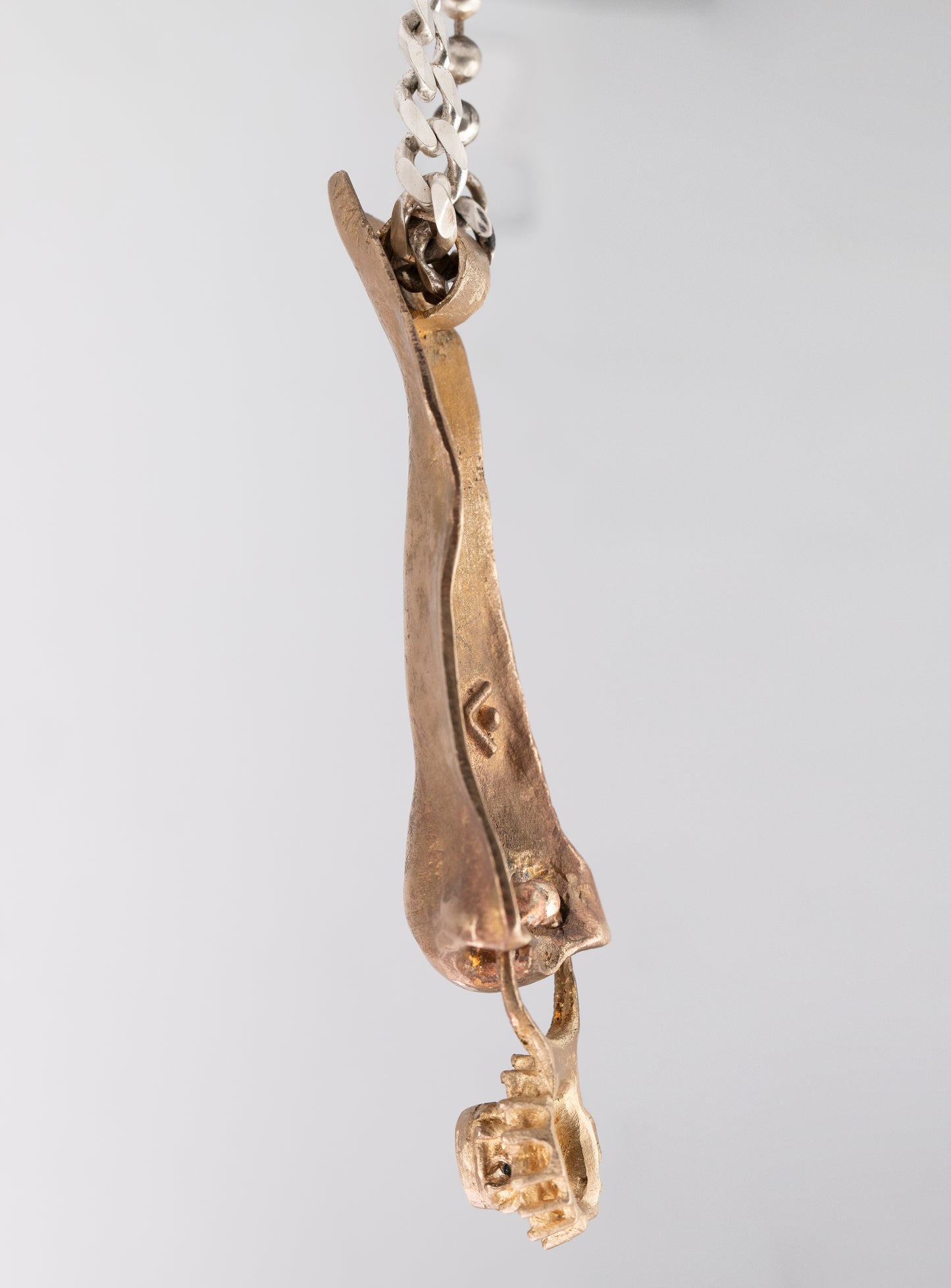 Nose pendant. Brass, topaz. / Wisior w kształcie nosa. Mosiądz, topaz.