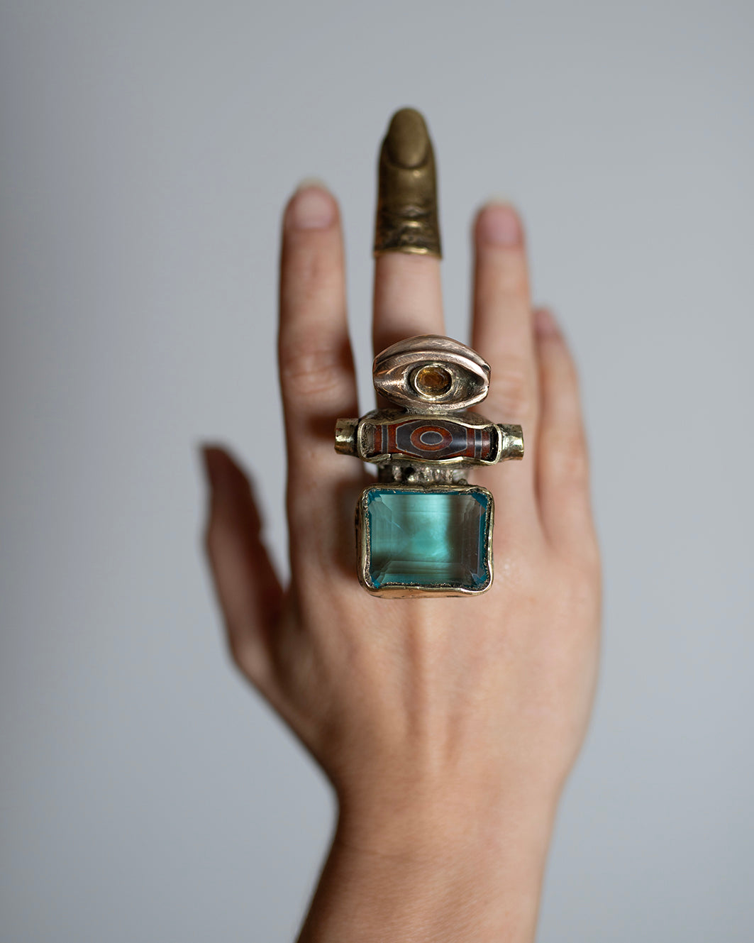Big ring Dzi. Brass, bronze, silver, laboratory topaz, natural citrine, 2 turquoises./ Wielki pierscien Dzi. Mosiadz, braz, srebro, topaz laboratoryjny, naturalny cytryn, 2 turkusy.