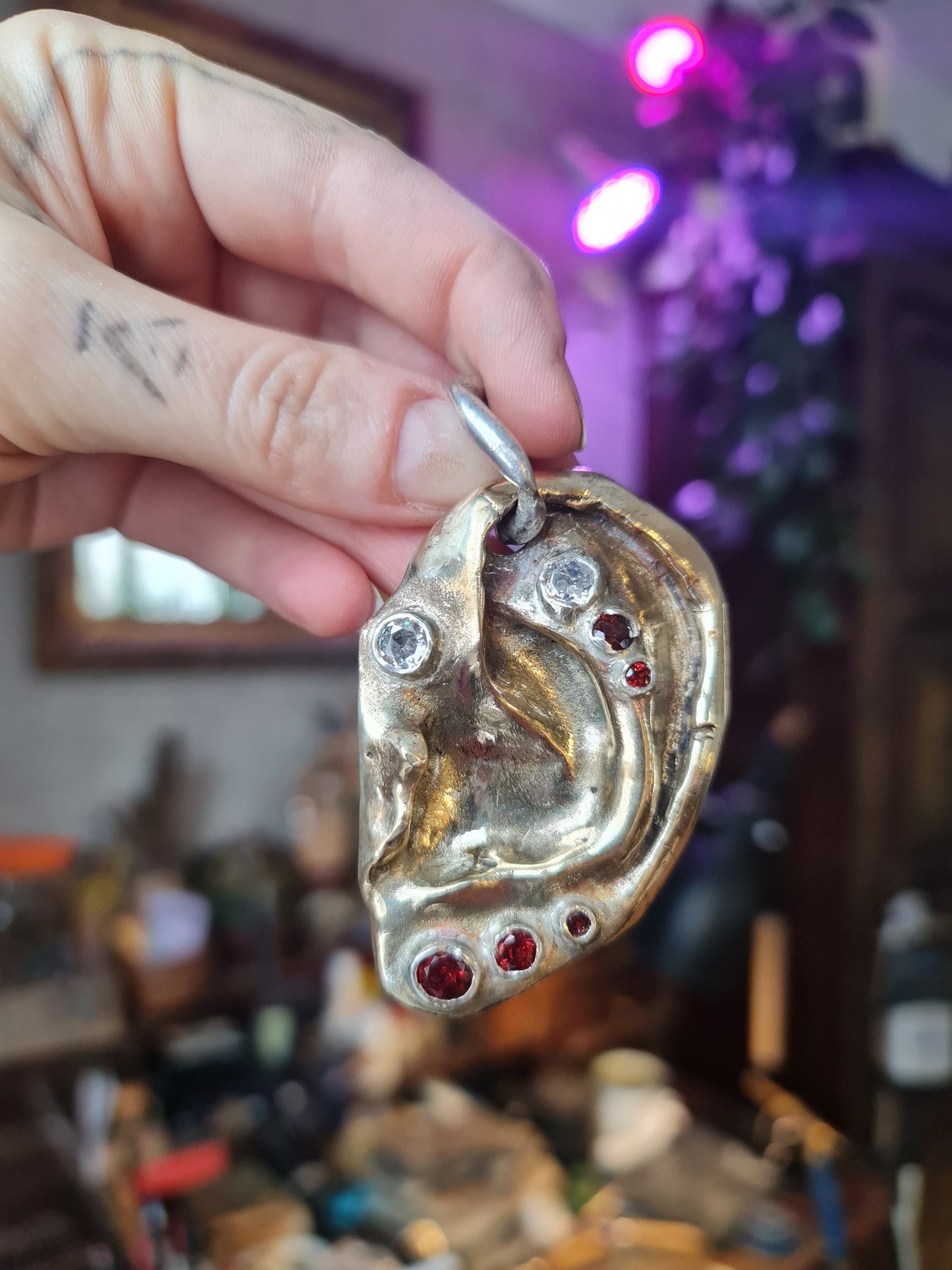 Ear pendant. Brass, 5 garnet stones, 2 zircons. / Wisior w kształcie ucha. Mosiadz, 5 kamieni granatów, 2 cyrkonie.